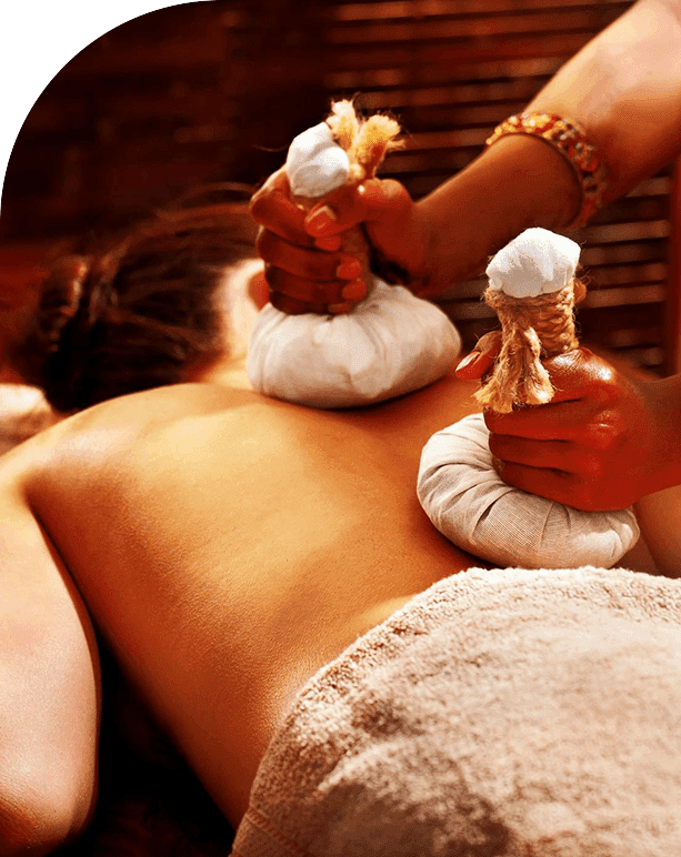 A woman getting a massage with hot stones on her back.
