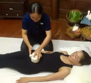 A woman is getting her legs waxed by a masseuse.