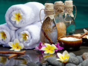 A spa setting with flowers and bottles of oil.